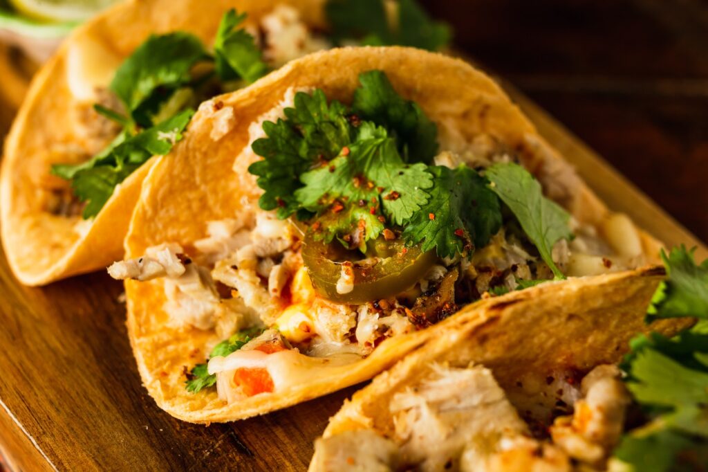A close view of a taco with chicken and jalapeno and cilantro