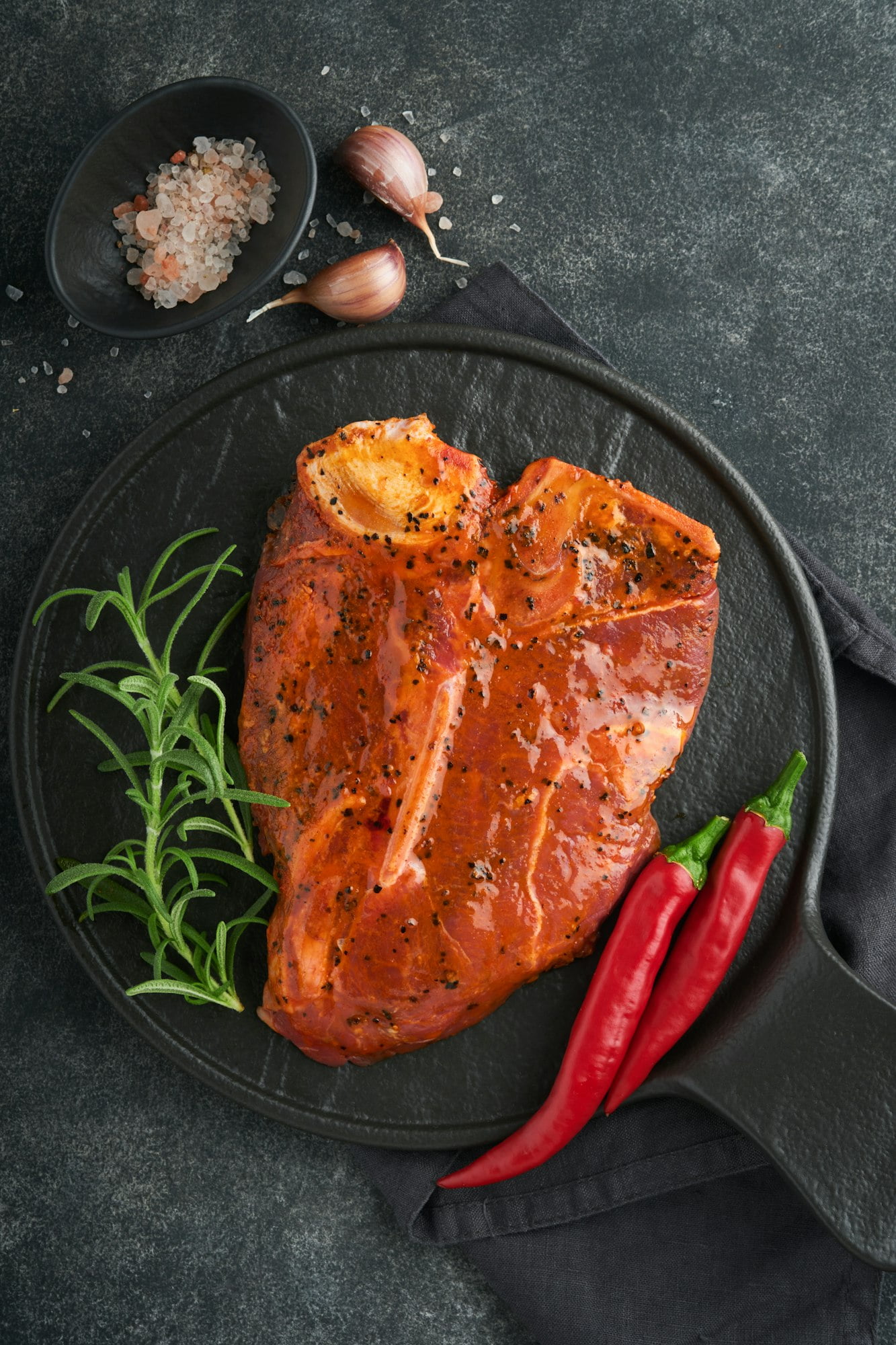 Raw steak t-bone or porterhouse. Steak t-bone or porterhouse in sauce with spices, salt and rosemary